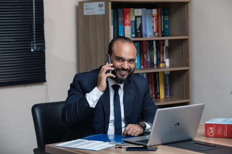 Avocat au téléphone à son bureau devant une bibliothèque de codes