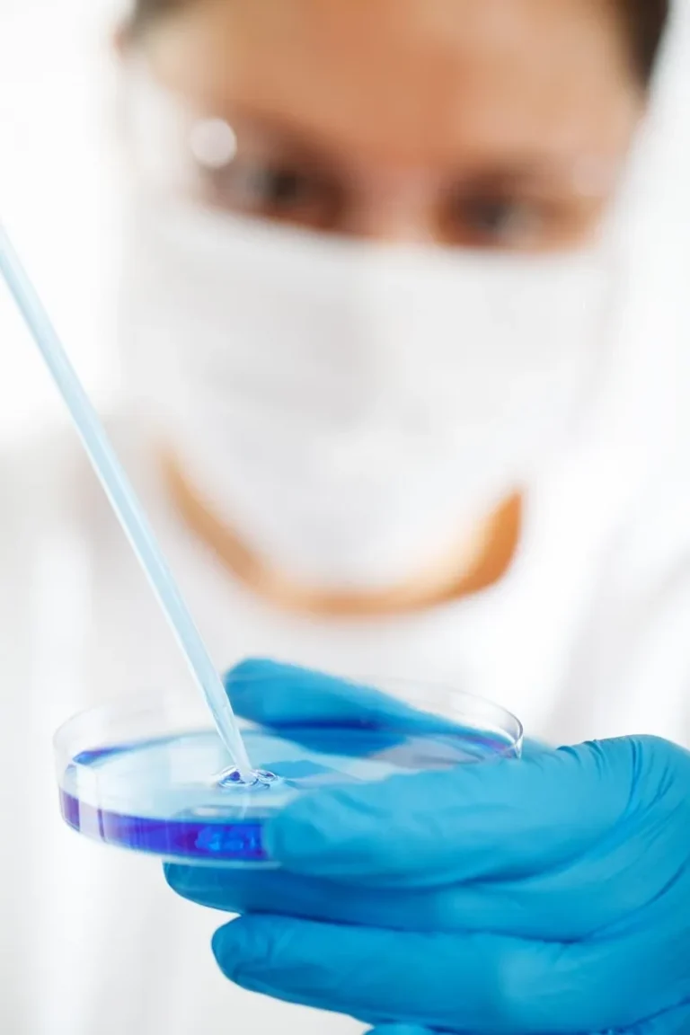 Laborantin masqué et ganté manipulant une boîte de Petri